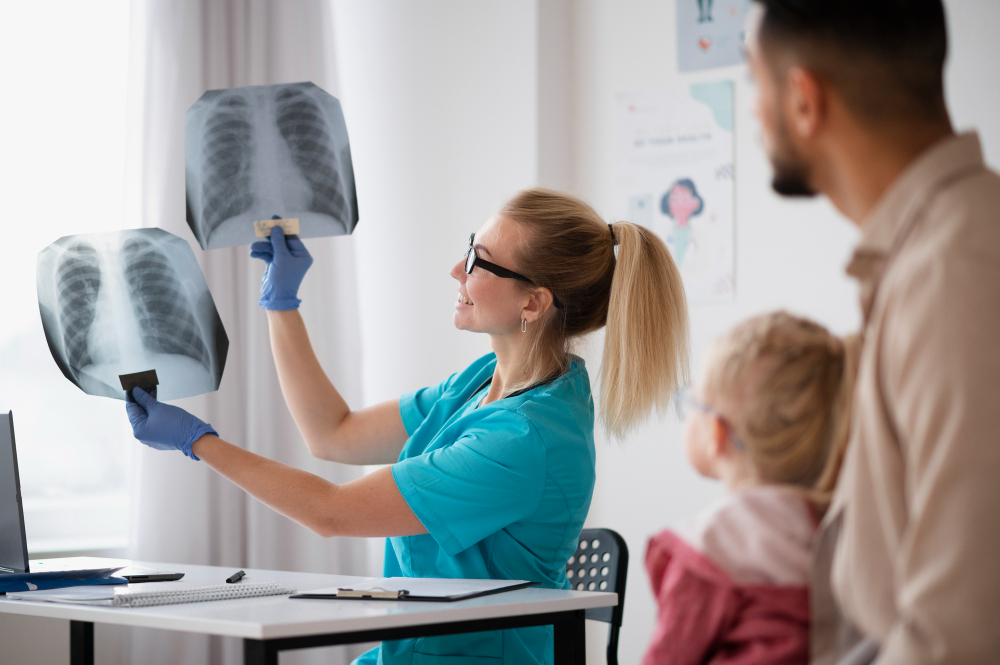 Pediatra mujer enseñando radiografía a padre e hija